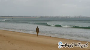 Guy walking and waves breaking at Lagos Beach (Meia Praia) in winter