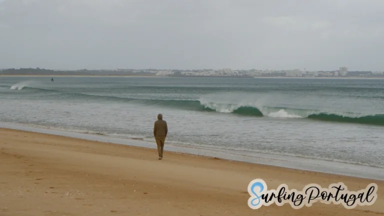 Guy walking and waves breaking at Lagos Beach (Meia Praia) in winter