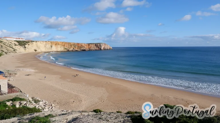 Bay of praia da Mareta on a sunny afternoon with some people walking on the sand