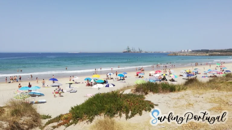 São Torpes beach on a summer day, with some surfers in the water