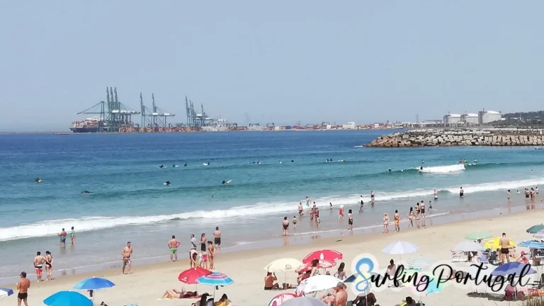 São Torpes beach on a summer day, with some surfers in the water