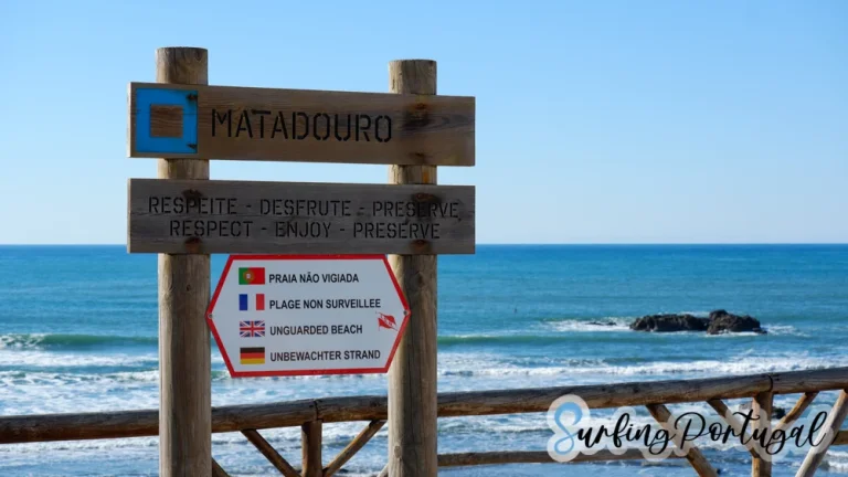 Wooden sign of Praia do Matadouro, in Ericeira, with the ocean in the background